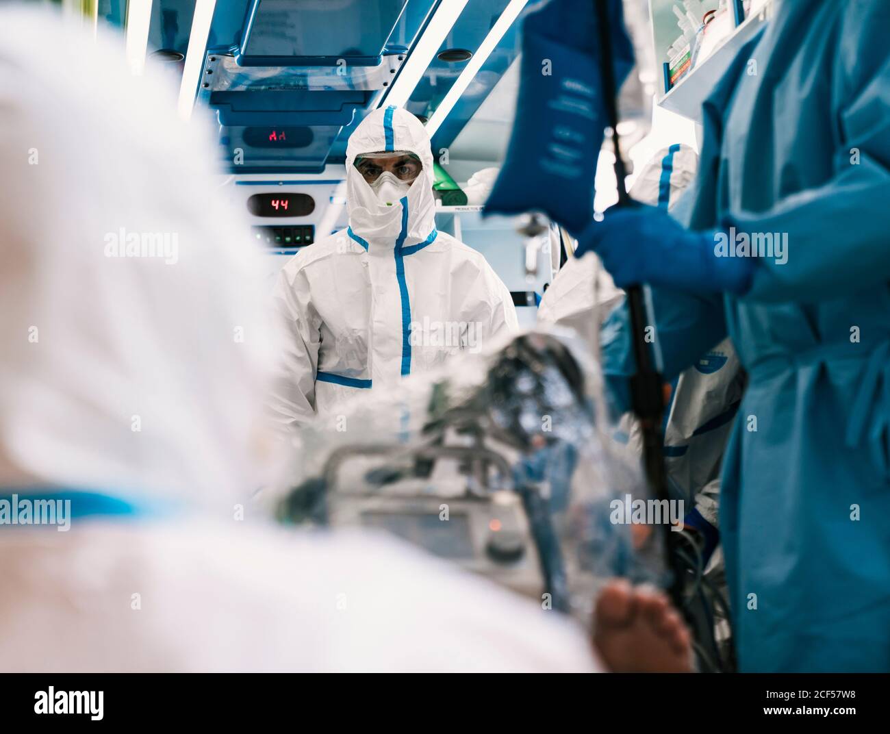 Gruppe von professionellen Ärzten in Schutzuniform im Krankenwagen stehen Auto mit Ausrüstung und Vorbereitung für den Patiententransport Stockfoto