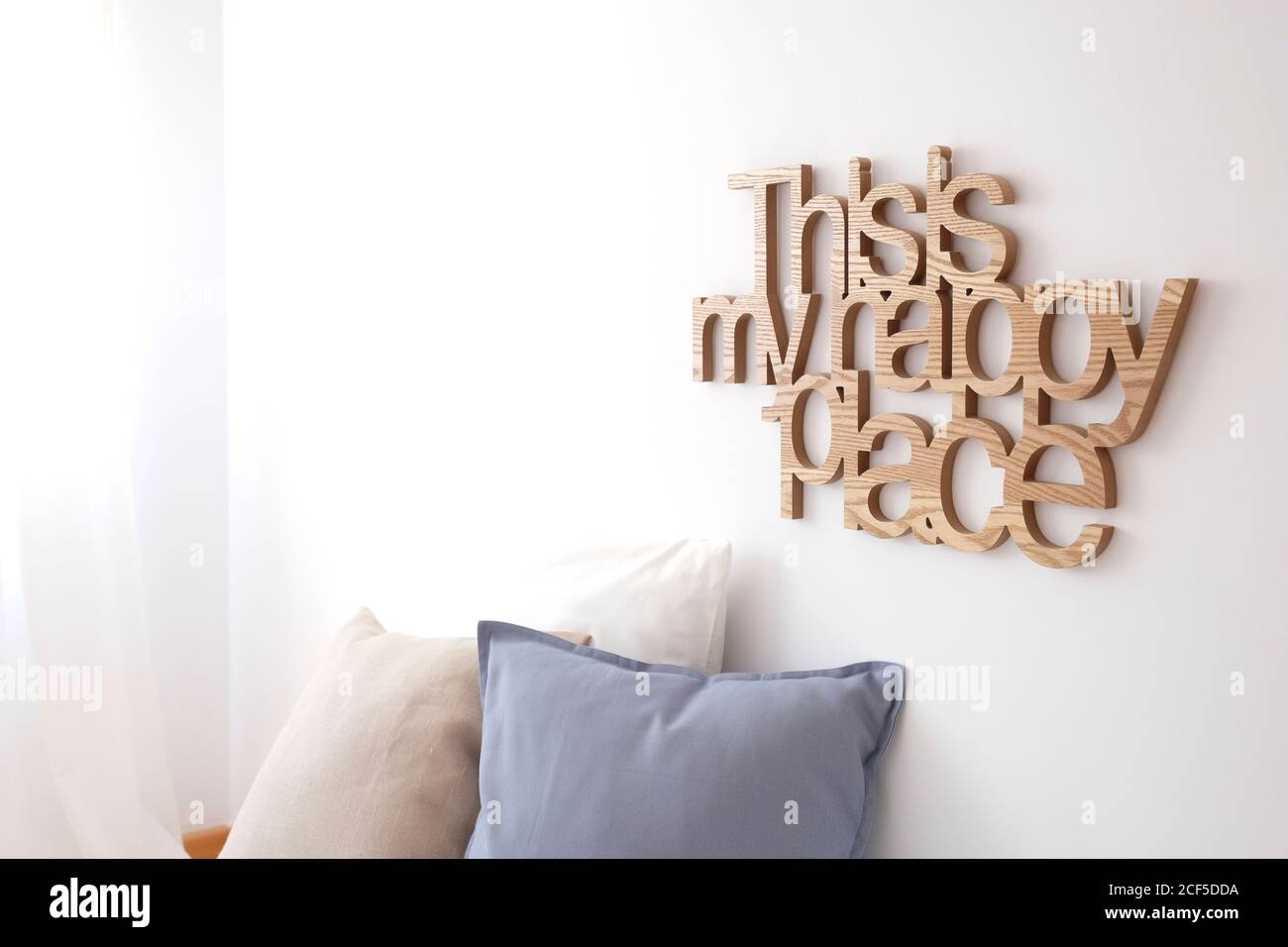 Dies ist meine glückliche Ort Inschrift an der weißen Wand befestigt Über Kissen im gemütlichen Wohnzimmer zu Hause Stockfoto