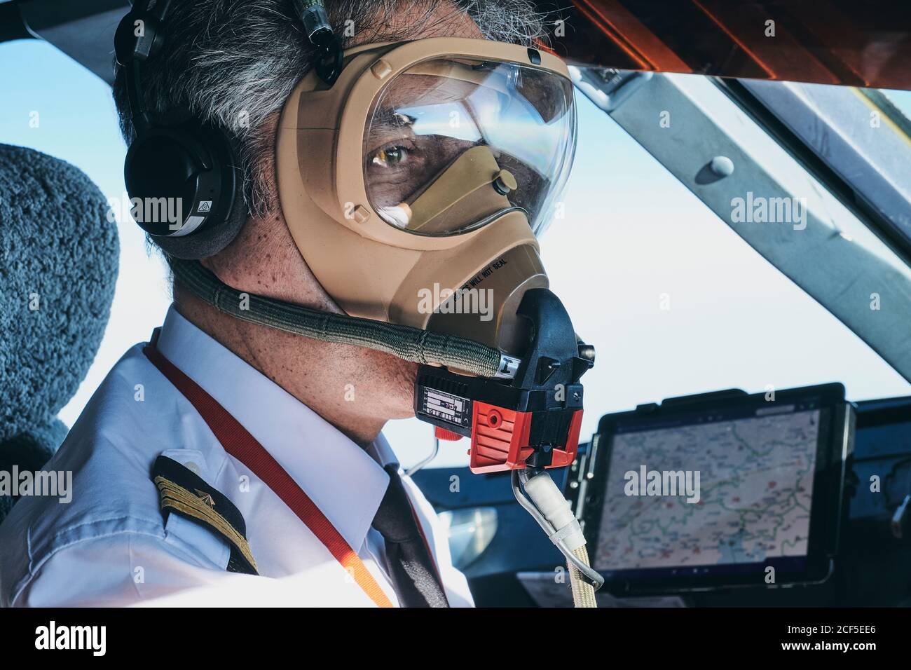 Pilot in Maske operierendes Flugzeug während des Fluges Stockfoto
