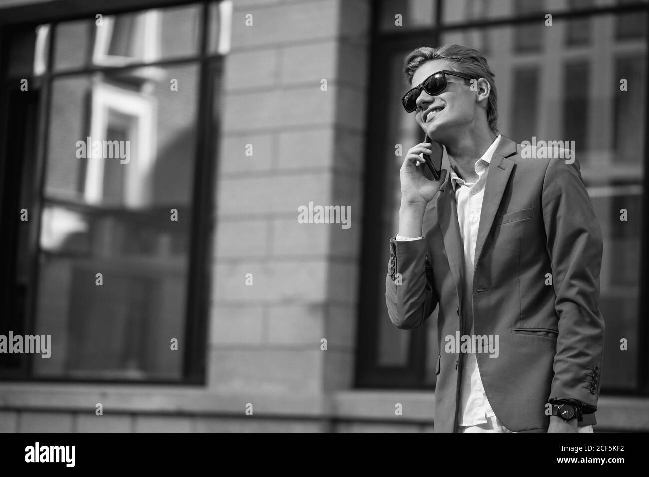 Lächelnde Geschäftsmann in Brillen am Telefon sprechen Stockfoto