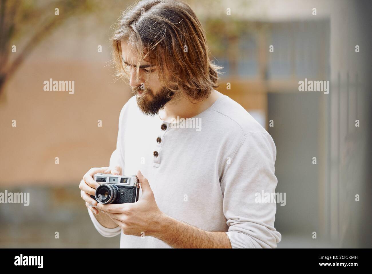 Junger bärtiger, hübscher Mann in legerer Kleidung, der Fotos gemacht hat Straße Stockfoto