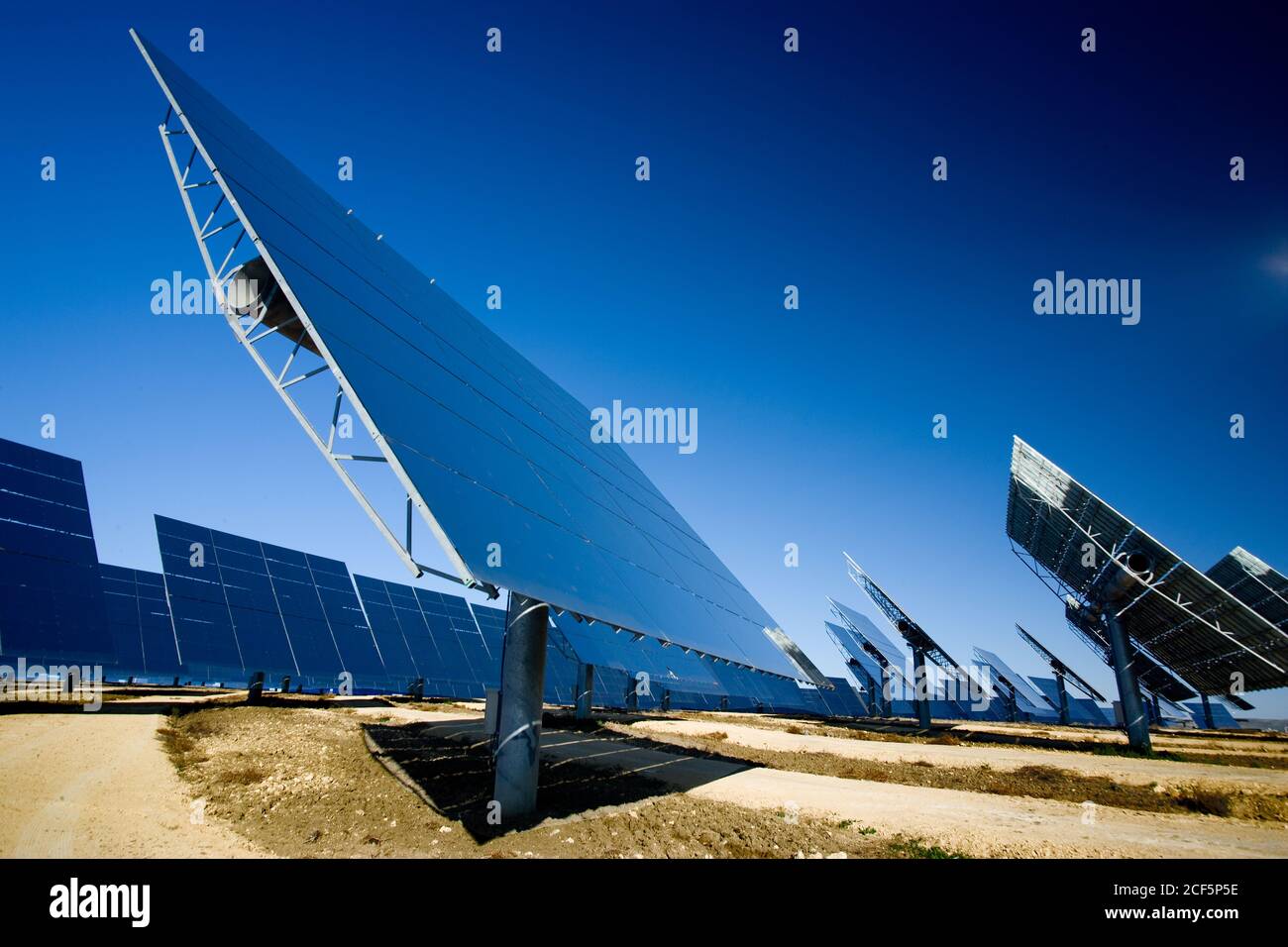 Moderne Sonnenkollektoren im Feld gegen wolkenlosen blauen Himmel installiert In Photovoltaik-Kraftwerk Stockfoto
