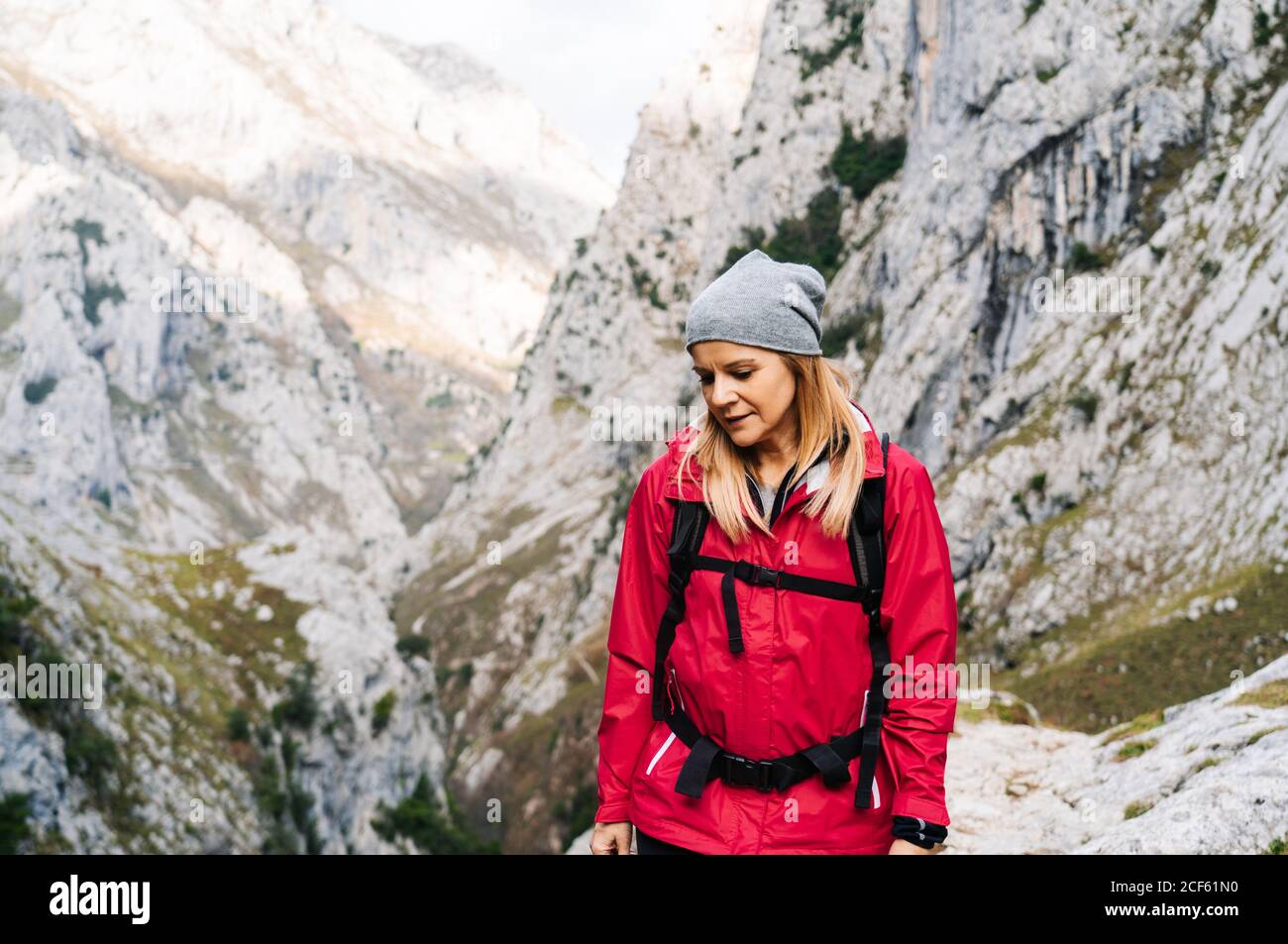 Aktive Frau Wanderer in roter Jacke mit schweren Rucksack zu Fuß in den Bergen in den Gipfeln Europas, Asturien, Spanien Stockfoto