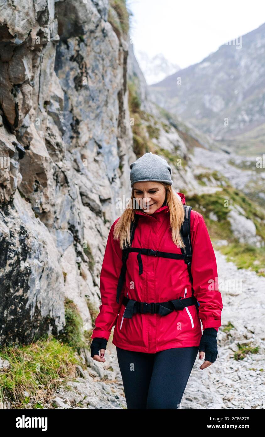 Aktive Frau Wanderer in roter Jacke mit schwerem Rucksack zu Fuß auf den Berg in den Gipfeln Europas, Asturien, Spanien Stockfoto