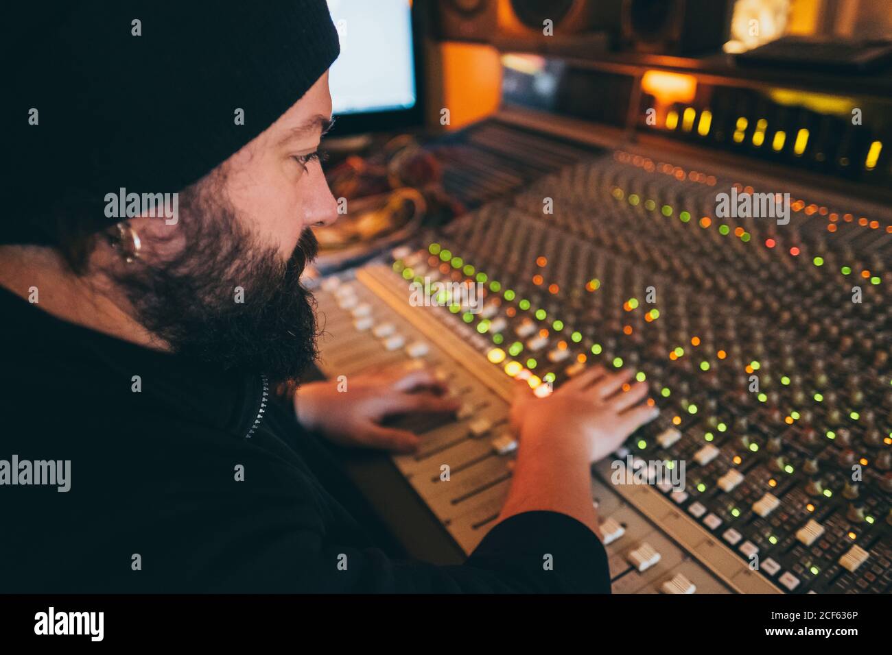 Ein Musiker, der in einem Studio in einem Equalizer-Instrument arbeitet Stockfoto