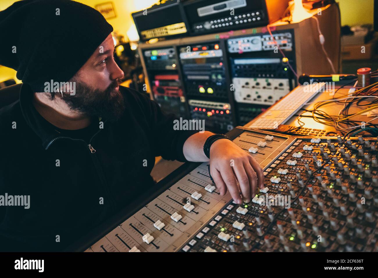 Ein Musiker, der in einem Studio in einem Equalizer-Instrument arbeitet Stockfoto