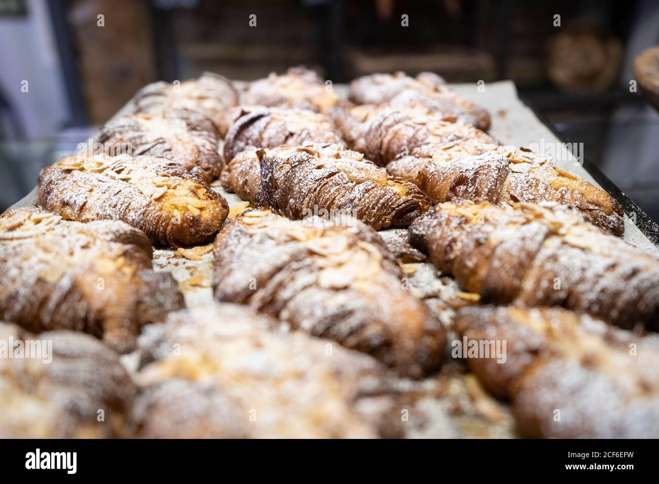 Von oben Komposition aus frisch gebackenen französischen Croissants mit Scheiben Mandeln und Zuckerpulver Stockfoto