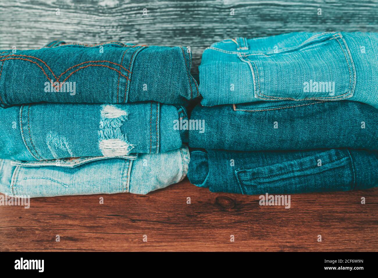 Jeans Hosen Bekleidung Einzelhandel. Denim-Kleidung auf Holzregal gefaltet zeigt Stile von notgekleideten Taschen und klassischen Schnitt wie Skinny, Bootleg Stockfoto