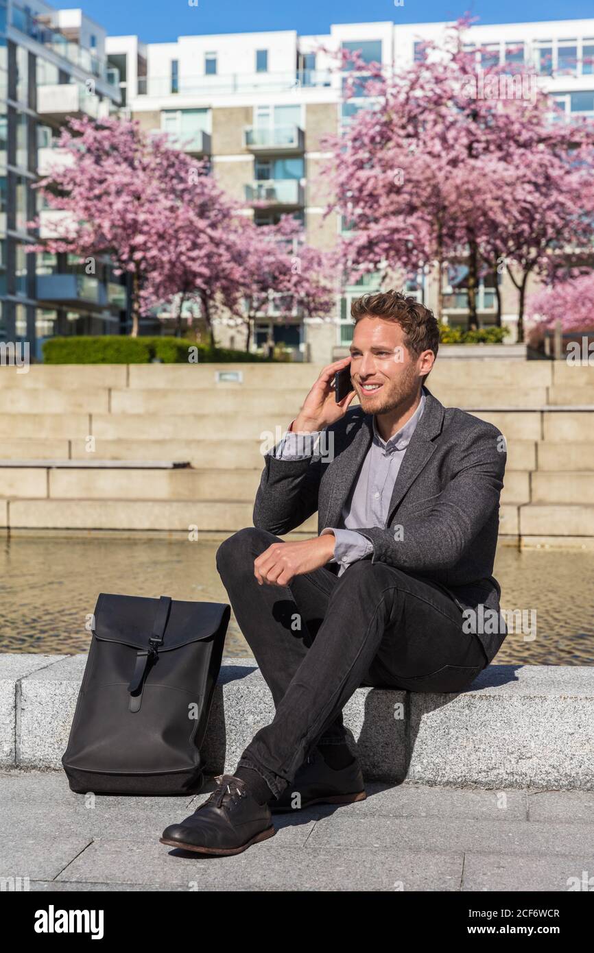 Mann, der auf dem Smartphone spricht. Geschäftsmann städtischen professionellen Geschäftsmann mit Handy lächelnd trinken Kaffee im Bürogebäude in der Stadt. Glücklich Stockfoto
