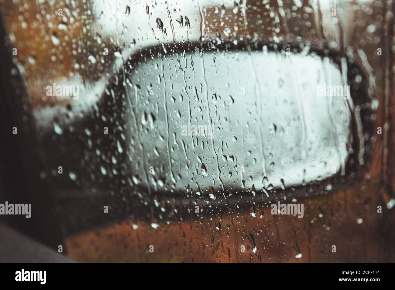 Flügel Spiegel des modernen Autos hinter der Tür Fenster mit abgedeckt Wassertropfen an regnerischen Tagen Stockfoto