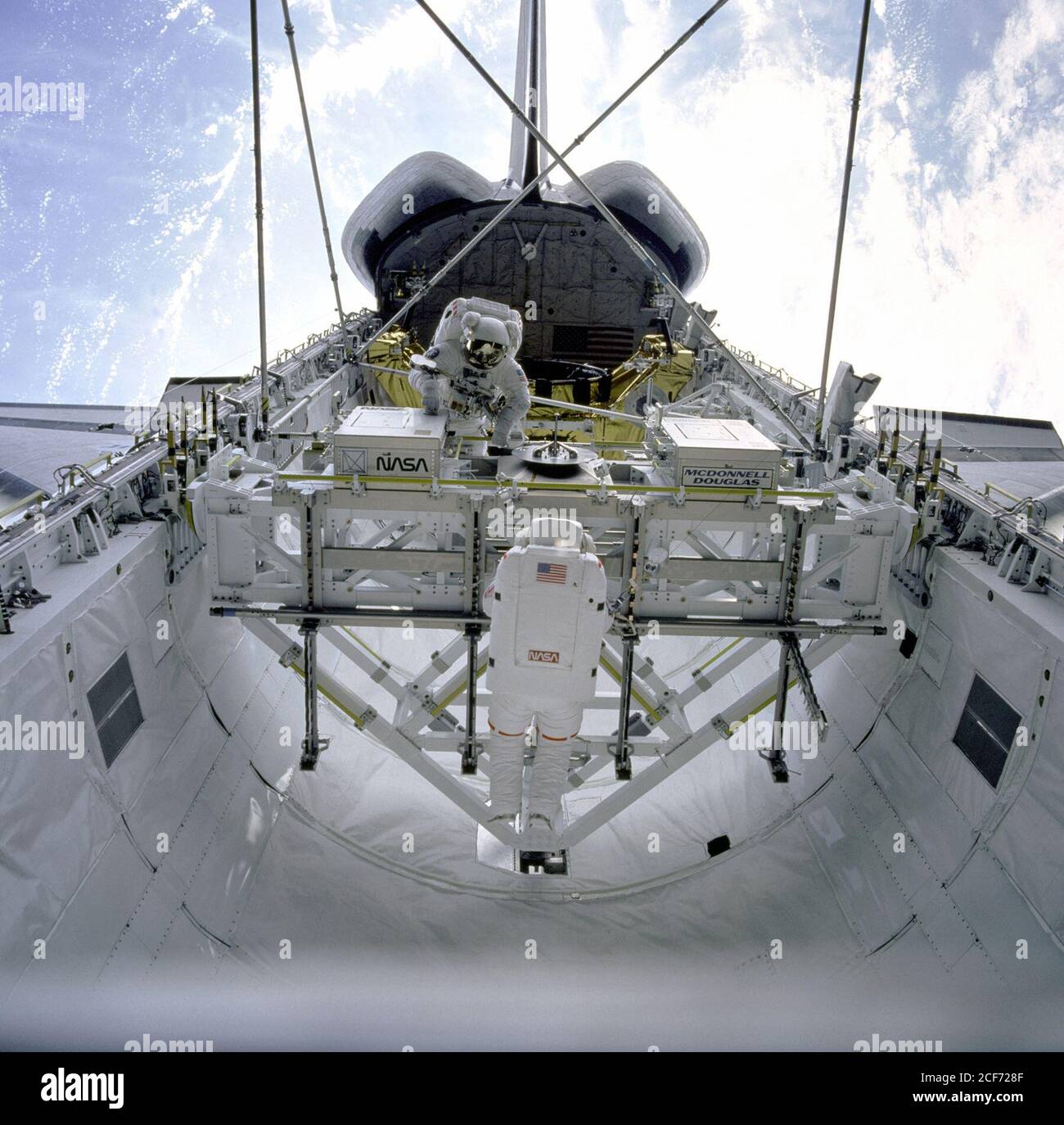 STS-49 Mission Spezialist (MS) Kathryn C. Thornton (im Vordergrund) gibt eine Strebe aus dem Mehrzweck Experiment Unterstützung Struktur (MPESS) Federbein Spender während der Montagestation von Extravehicular Activity Methoden (ASEM) Verfahren in der Ladebucht der Endeavour. MS Thomas D. Akers, positioniert auf der gegenüberliegenden Seite des MPESS, wartet auf Thornton zur hand ihm die endgültige Strebe. Die beiden Astronauten bauen die ASEM-Struktur während der vierten EVA der Mission. Die ASEM-Struktur, gesperrt an vier Ecken, Nutzlast Aufbewahrung Riegel Baugruppen (PRLAs), erhebt sich über der Ladebucht. In der Zeitmessung Stockfoto