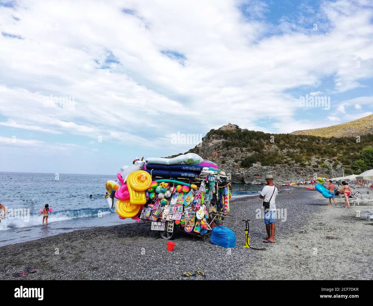 MARINA DI CAMEROTA, ITALIEN - 05. Aug 2020: Straßenhändler von hinten verkauft seine Waren am Strand von Marina di Camerota Stockfoto
