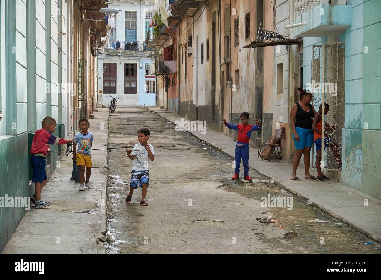 KUBA - 28. DEZEMBER 2018: Kleine schwarze Jungs haben Spaß auf engen Straßen zwischen alten Gebäuden Stockfoto