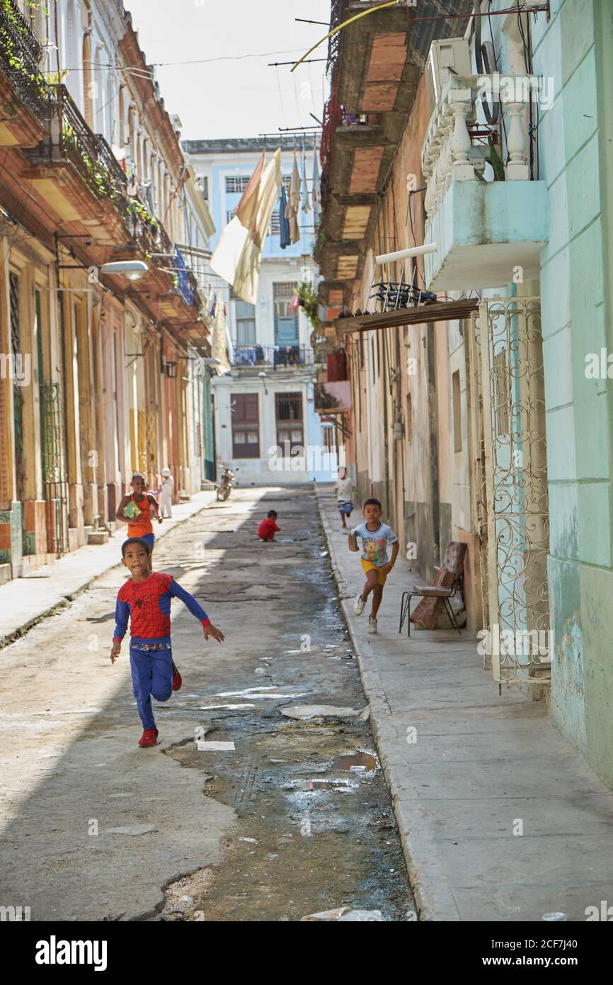 KUBA - 28. DEZEMBER 2018: Kleine schwarze Jungs haben Spaß auf engen Straßen zwischen alten Gebäuden Stockfoto