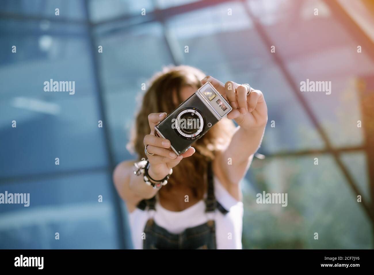 Von oben von jungen unkenntlich weiblich halten Fotokamera in Ausgestreckte Hände und fotografieren, während man an der Glaswand steht Stockfoto