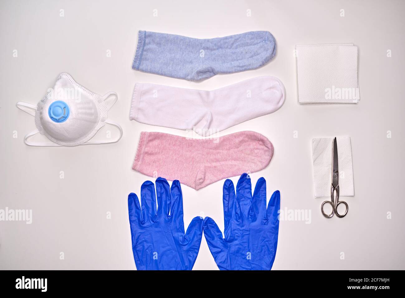 Draufsicht auf Socken Handschuhe Serviette und Schere zu machen Gewebemaske während der Quarantänezeit des Coronavirus zum Schutz Stockfoto