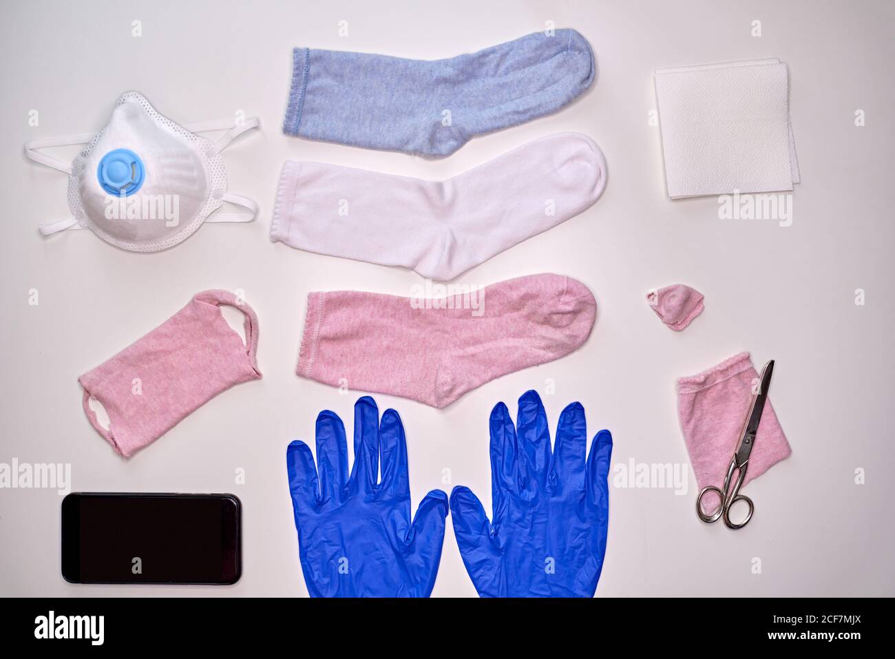 Draufsicht der Socken Handschuhe Smartphone Serviette und Schere zu Machen Sie Stoffmaske während Quarantänezeit von Coronavirus zum Schutz Stockfoto