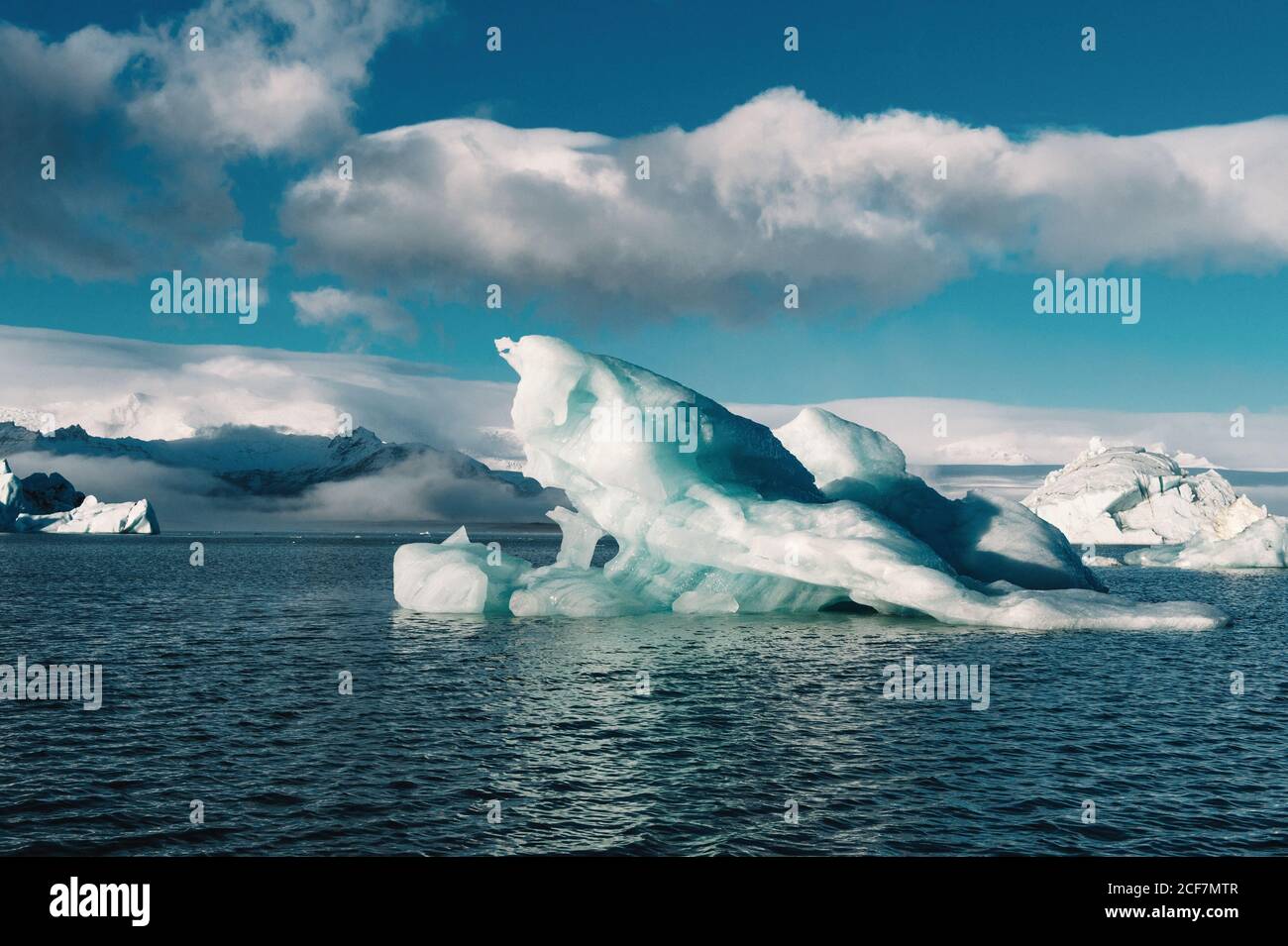 Malerischer Blick auf Eis auf der Wasseroberfläche im Winter und Blauer Himmel mit Wolken in Island Stockfoto