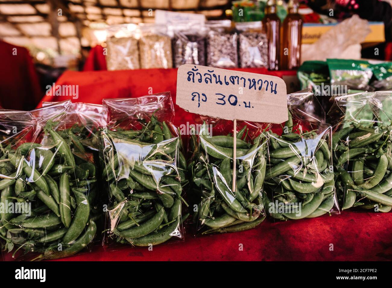 Oben von den grünen Erbsen die Schoten in den Paketen auf dem Regal Mit Preisschild in Outdoor-Markt in Thailand Stockfoto