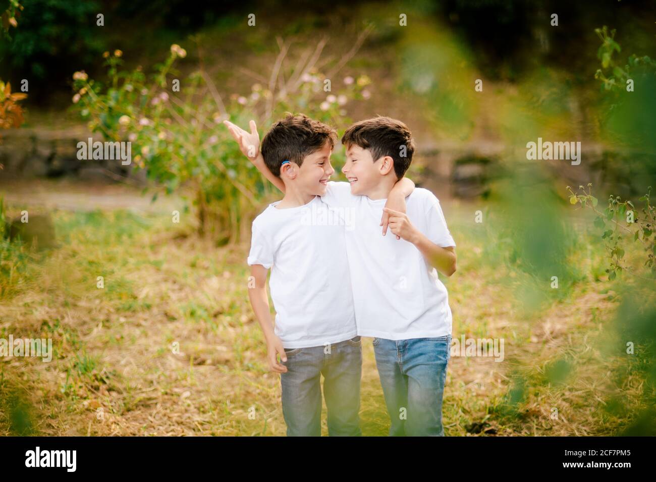 Glückliche Zwillinge Jungen umarmen und einander in parken Stockfoto
