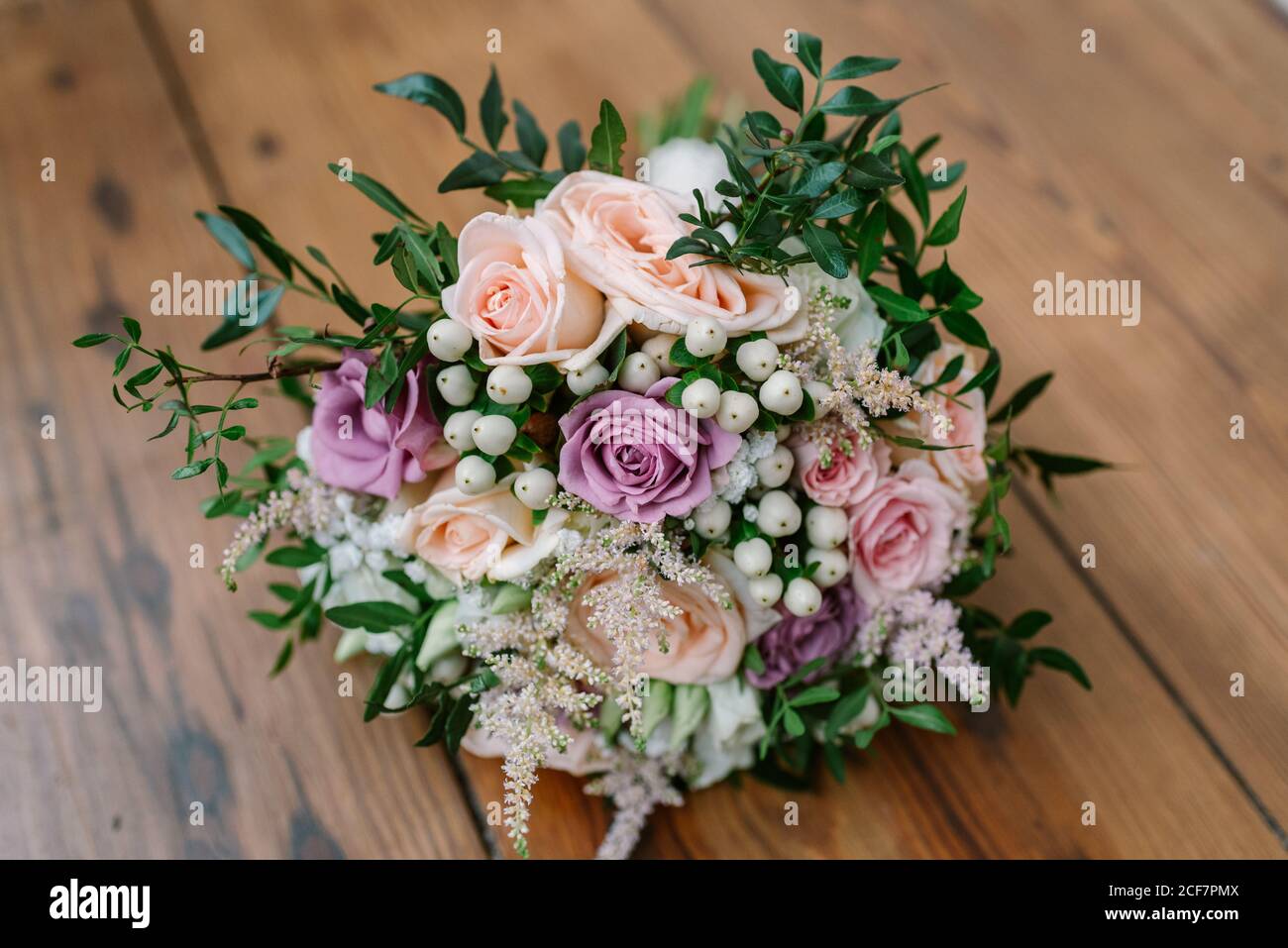 Schöne zarte Hochzeit Bouquet mit rosa und weißen Blumen und Dekorative grüne Pflanzen auf Holztisch Stockfoto