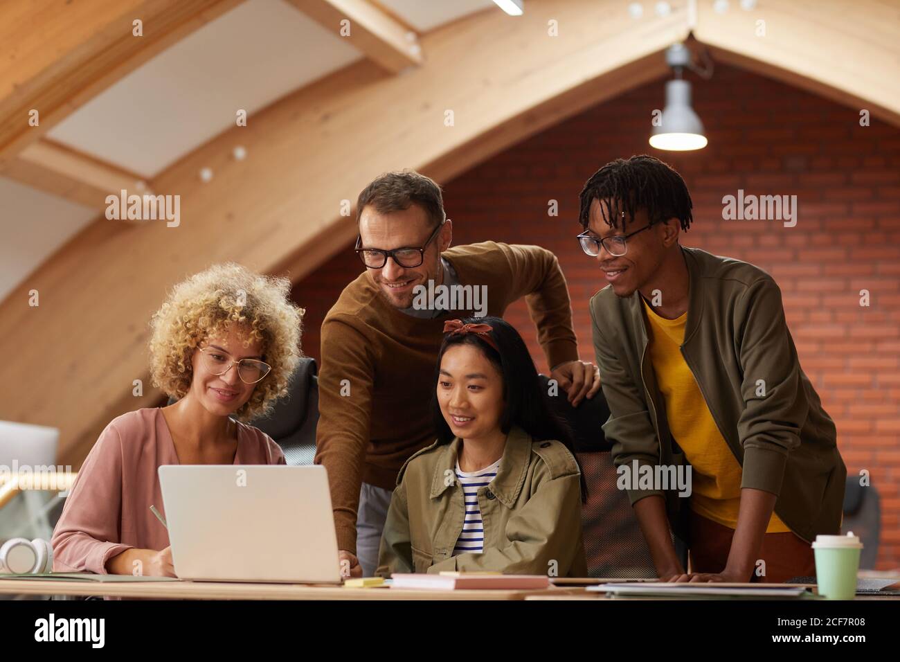 Gruppe von kreativen Geschäftsleuten, die online auf Unternehmenspräsentation zuschauen Laptop zusammen im Büro Stockfoto