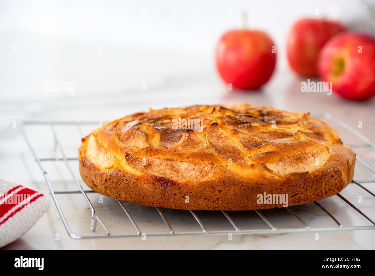 Frisch gebackener Apfel Zimt Tee Kuchen mit roten Äpfeln in Hintergrund Stockfoto
