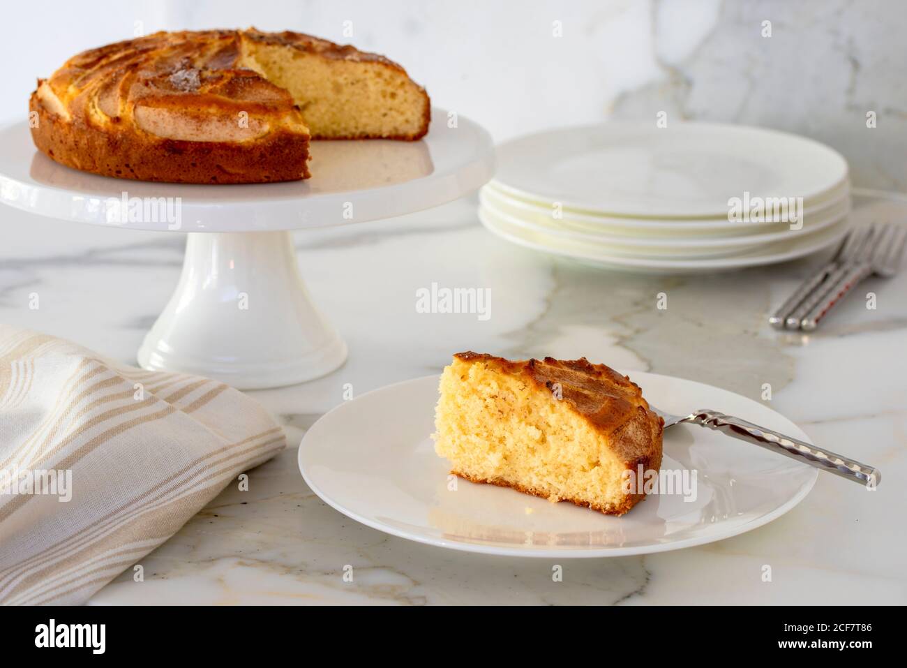 Schneiden Sie auf dem Ständer ein Stück Apfeltee-Kuchen mit Kuchen Im Hintergrund Stockfoto
