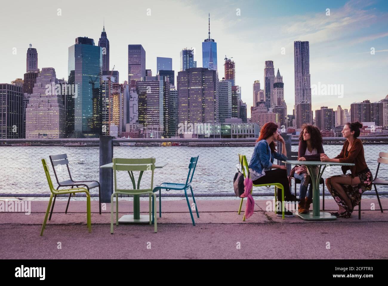 Freunde sitzen auf der Terrasse mit New york Hintergrund am Abend Stockfoto