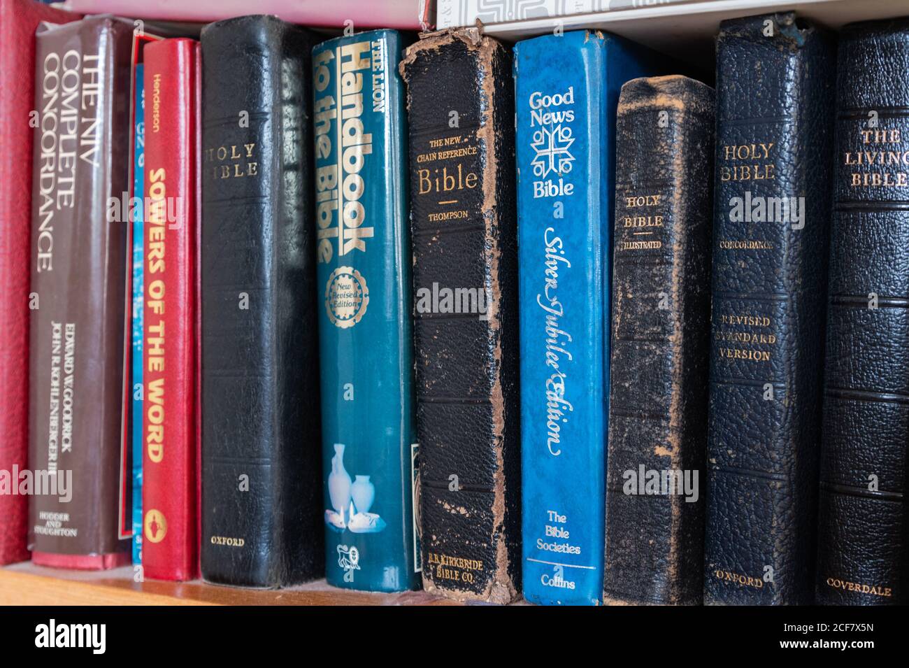 Bibeln und andere religiöse und christliche Religionsbücher auf einem Bücherregal. Stockfoto