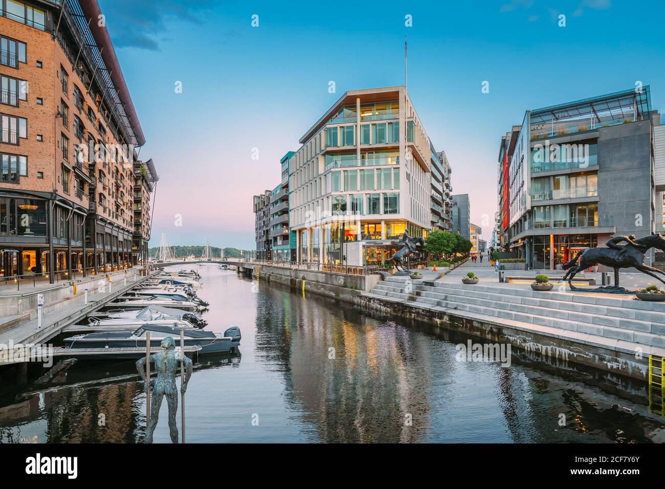 Oslo, Norwegen. Ansicht von mehrstöckigen Wohnhäusern im Aker Brygge Bezirk im Sommerabend. Berühmter Und Beliebter Ort. Pier Jetty Mit Booten. Stockfoto