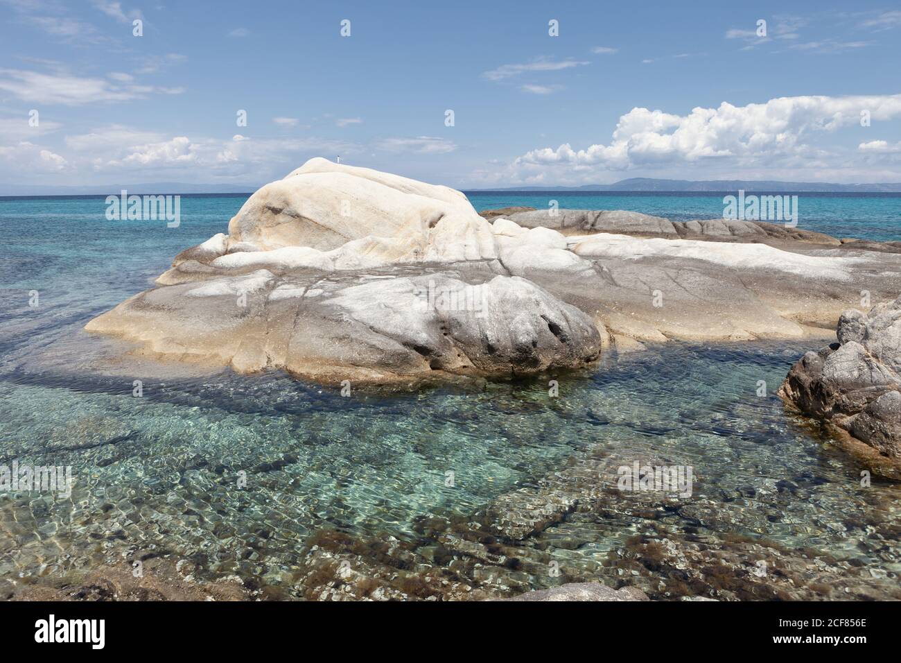 Malerische weiße felsige Formation mit klarem kristallklarem Meerwasser in strahlendem Sonnenschein bedeckt, Chalkidiki, Griechenland Stockfoto
