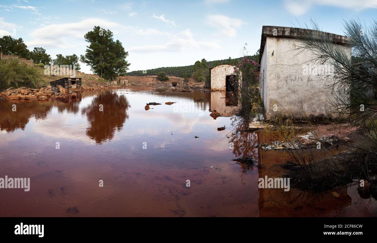 Verlassene Gebäude in La Naya, einem Bergbaudorf in Riotinto, Huelva, von rotem Wasser überflutet Stockfoto