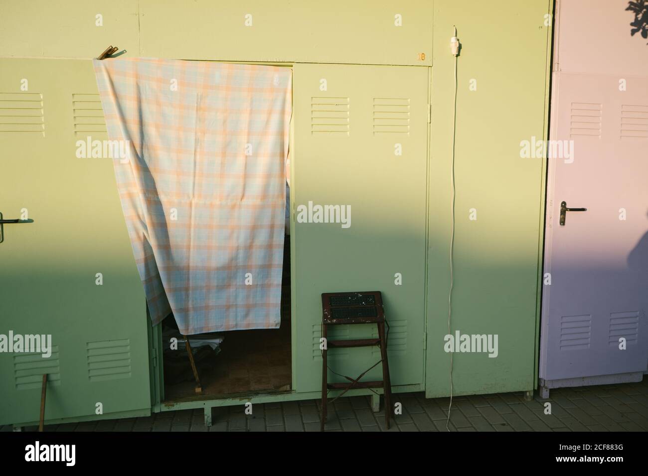 Schäbig verwitterte grüne Metallhäuser auf Bürgersteig in der Stadt Bereich während sonnigen Sommertag Stockfoto