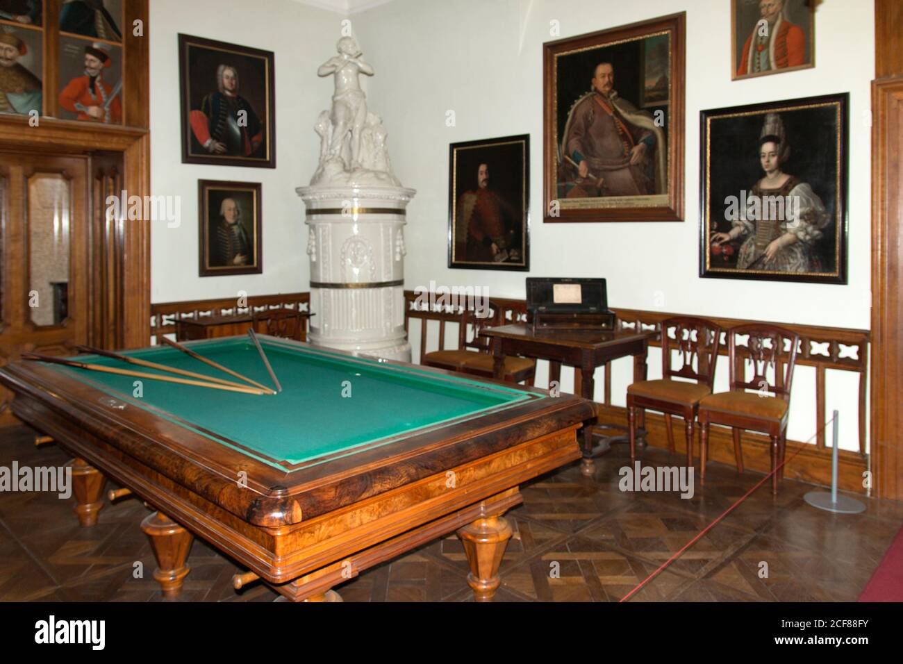 Spielzimmer mit Billardtisch im ehemaligen Jagdschloss des Grafen Gyula Andrássy. Weißer Porzellanofen in der Ecke. Stockfoto