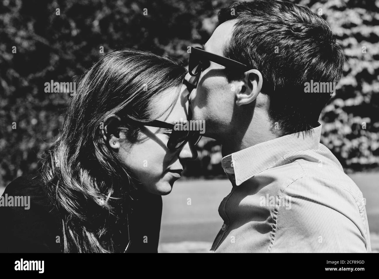 Seitenansicht der Ernte Freund zärtlich küssen Freundin in Stirn Während sie in der Stadt nahe beieinander stehen Stockfoto