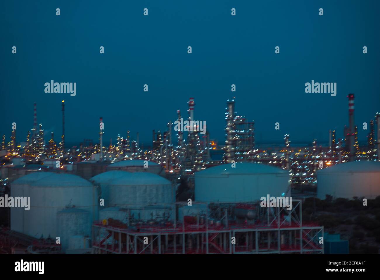 Von oben des zeitgenössischen Fabrikkomplexes mit Gebäuden und Rohren Leuchtet nachts im Industriegebiet Stockfoto