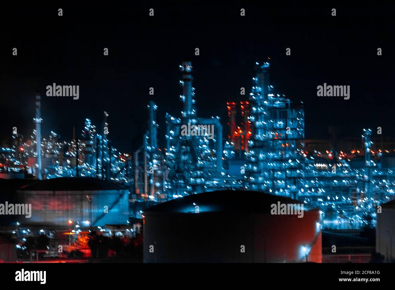Von oben des zeitgenössischen Fabrikkomplexes mit Gebäuden und Rohren Leuchtet nachts im Industriegebiet Stockfoto