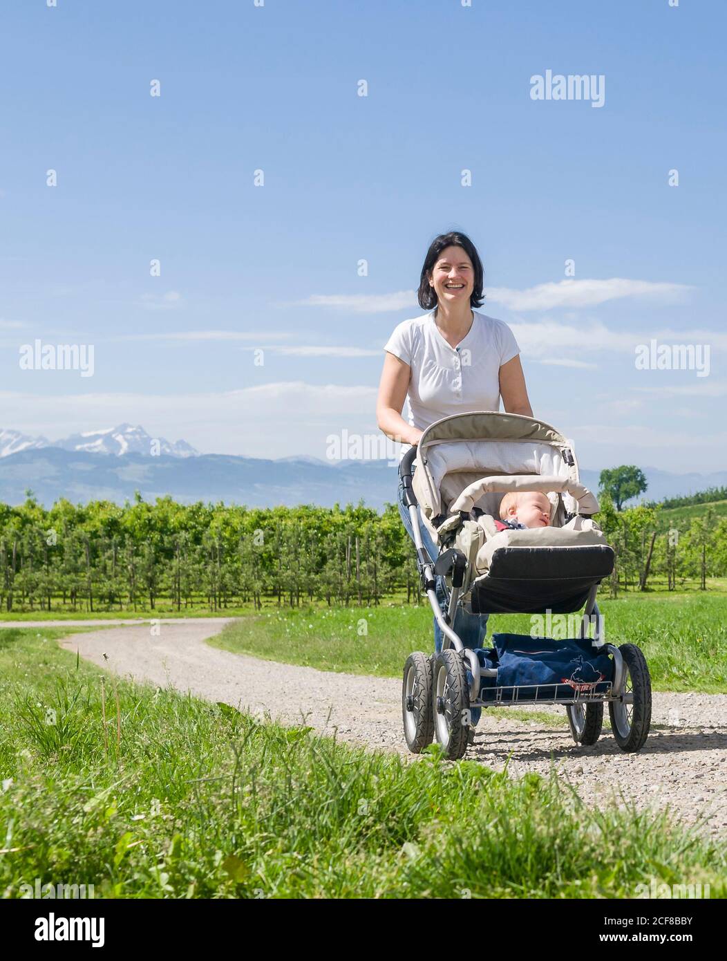 Junge Frau macht eine entspannte Tour mit ihrem kleinen Sohn Im Kinderwagen Stockfoto