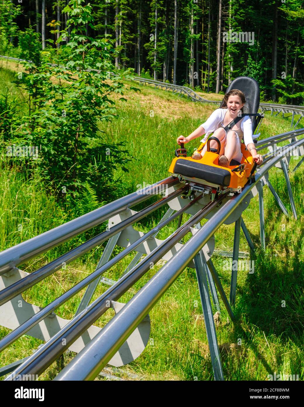 Junger Teenager auf Sommerrodelbahn Stockfoto