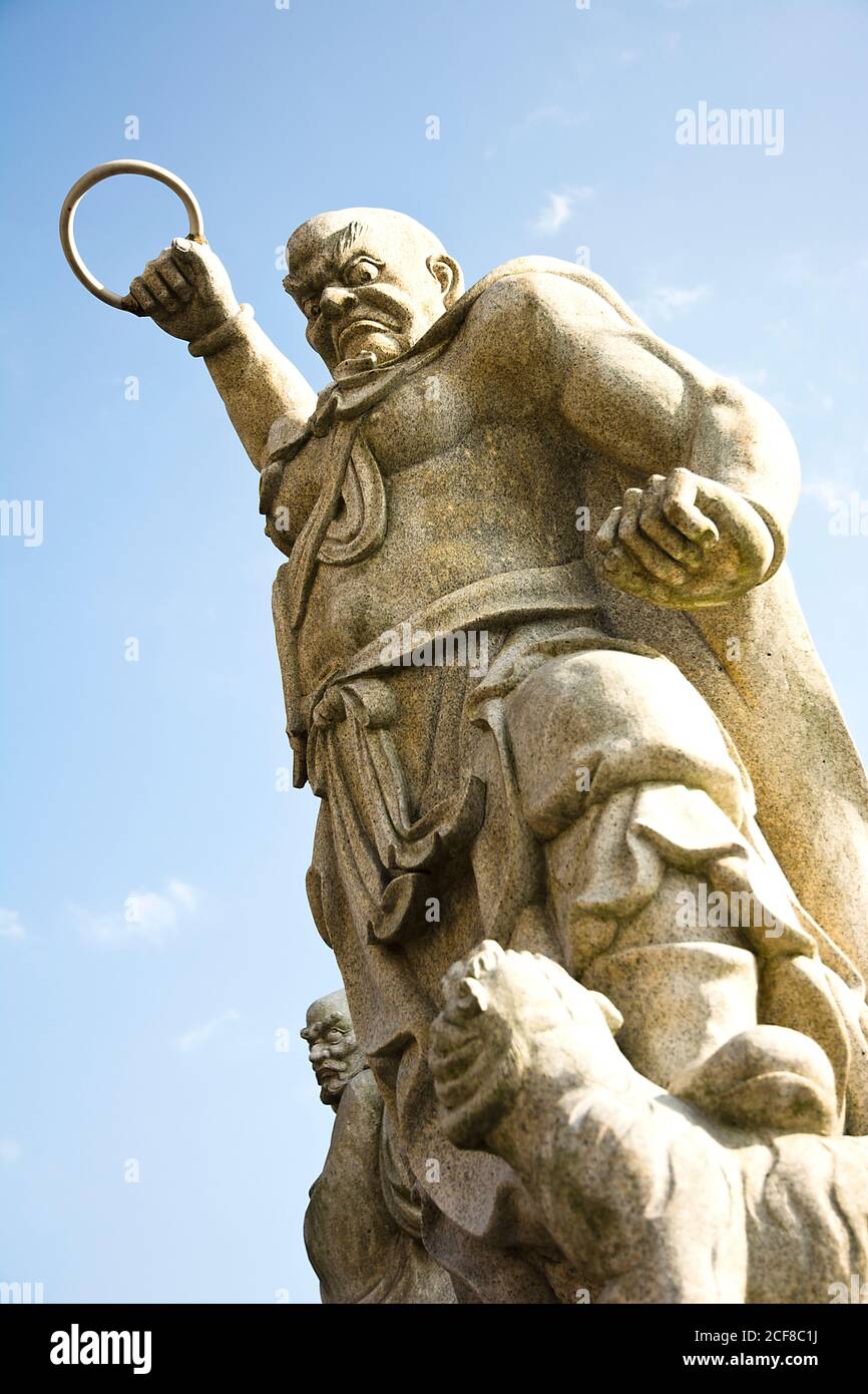 Heftig aussehende Statue, die mit erhobener Faust den Ring hält Stockfoto
