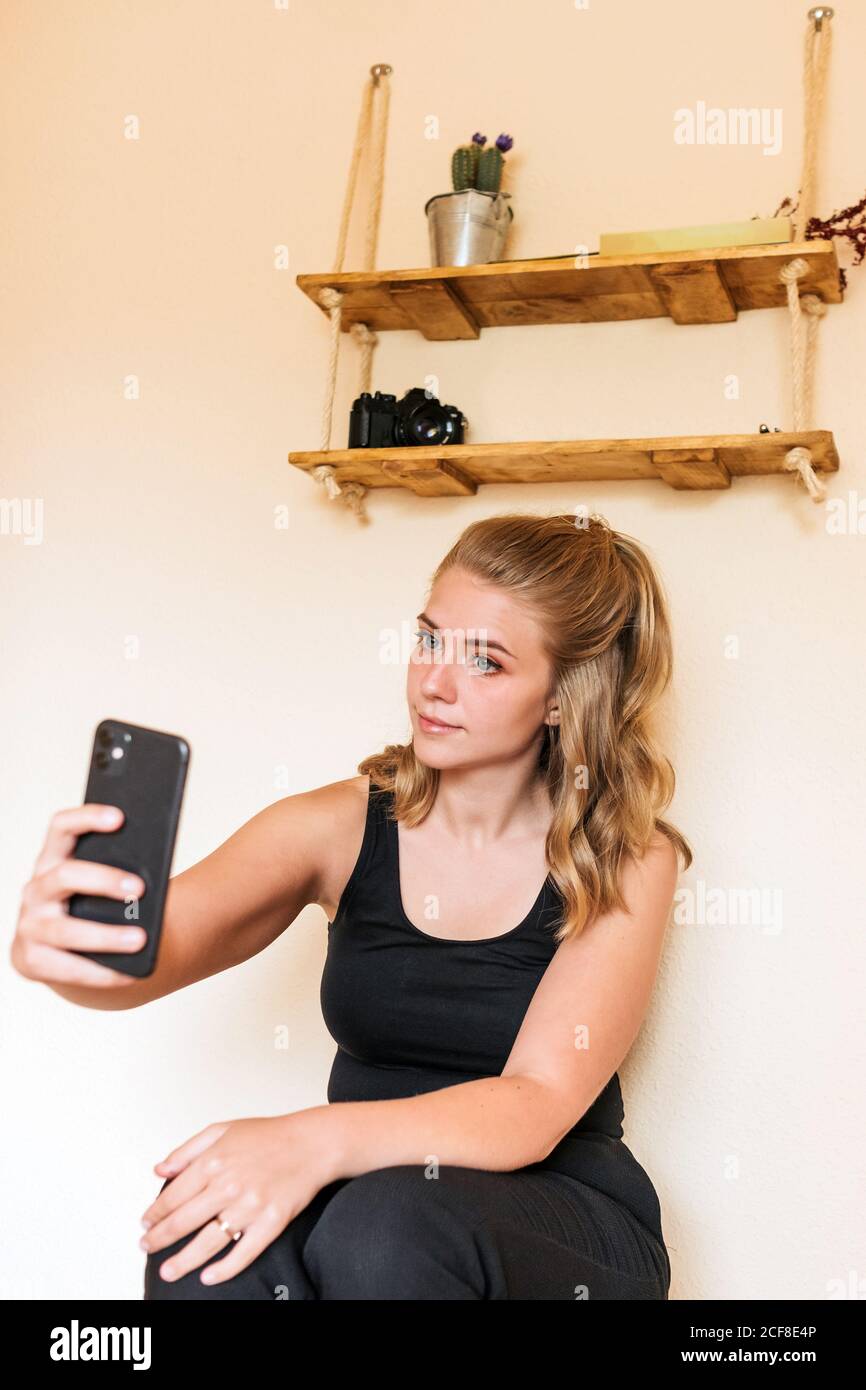 Junge Frau mit Handy zu Hause Stockfoto