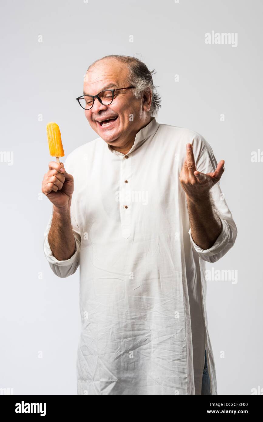 Indischer alter Mann Essen Schokolade Eis in Kegel oder Mango Candy Bar Stockfoto