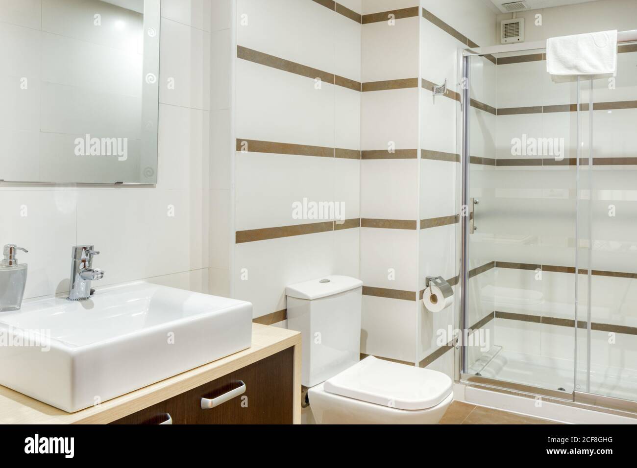 Die Inneneinrichtung des Badezimmers ist in minimalistischem, modernem Stil und weiß gehalten Fliesen mit Duschkabine Stockfoto