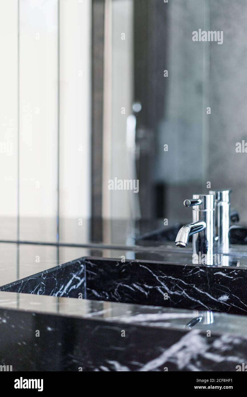 Rechteckiges Waschbecken und glänzenden Stahlhahn im luxuriösen Badezimmer in Tageslicht Stockfoto