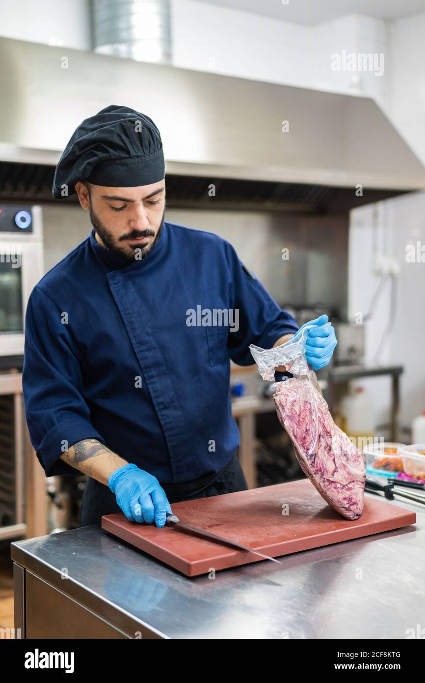 Kochen Sie mit einem großen Stück rohem Fleisch in der Küche Stockfoto