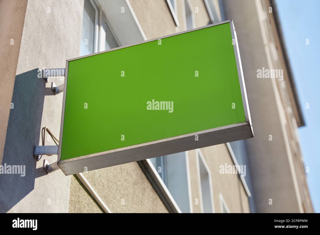 Grünes leeres Zeichen als Logo-Modell-Vorlage auf einem Hauswand Stockfoto
