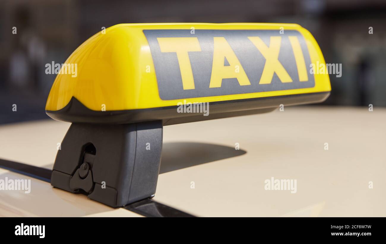Gelbes Taxi-Symbol auf dem Dach des Autos in der Stadt Stockfoto