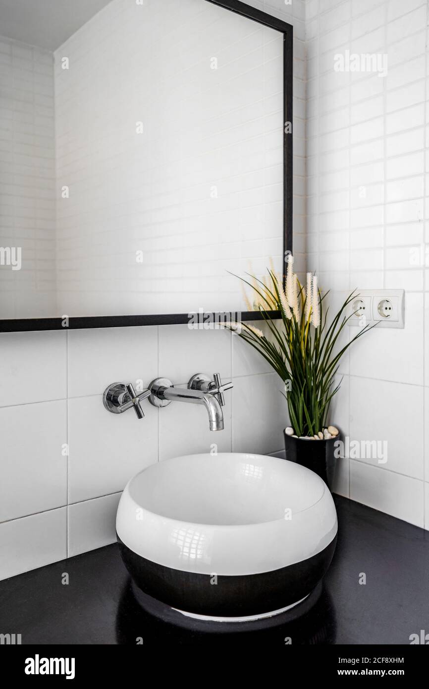 Modernes Badezimmer mit großem Spiegel über der stilvollen Theke Waschbecken Stockfoto