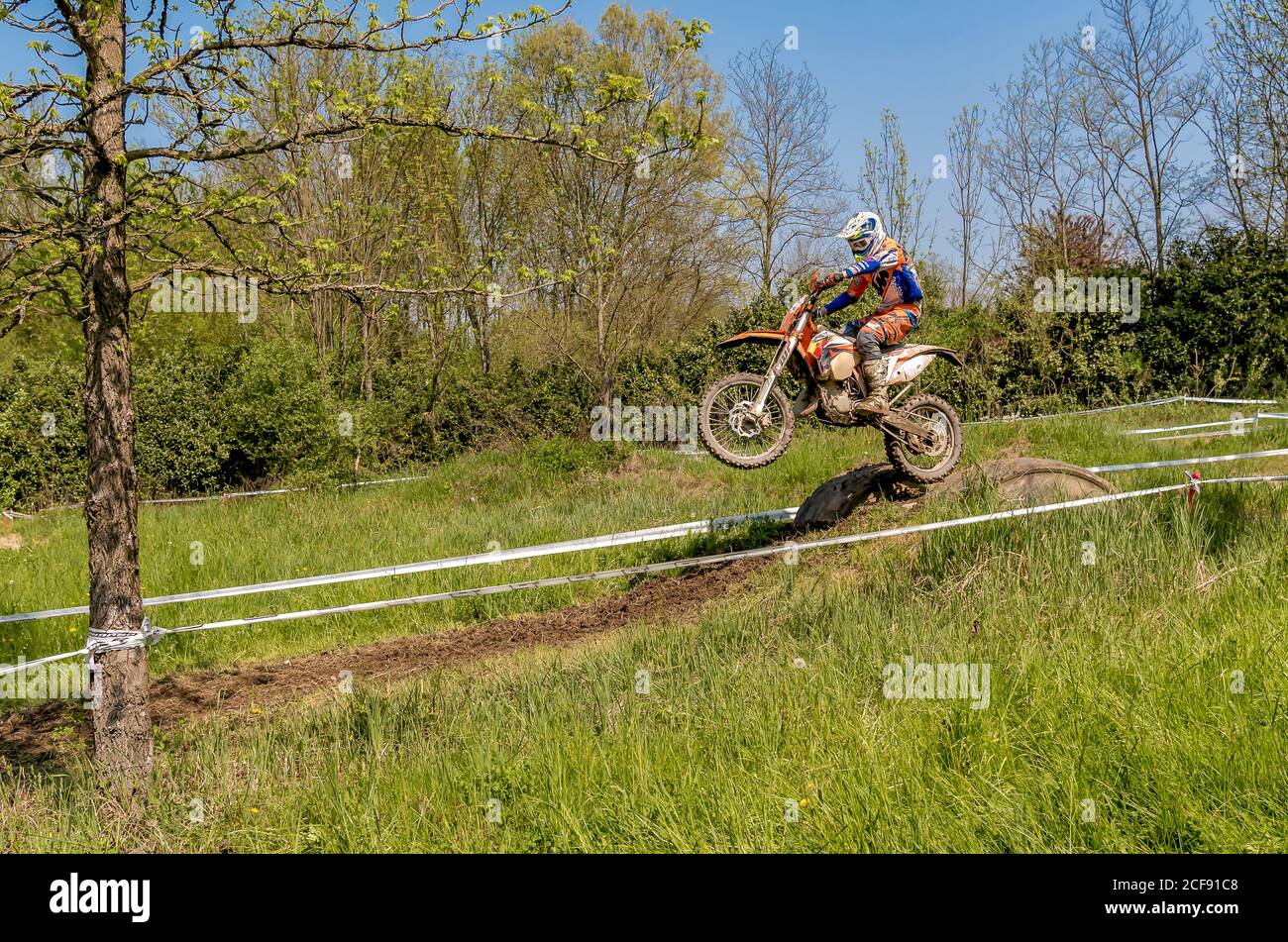 Biandronno, Lombardei, Italien - 22. April 2018: Motocross-Fahrer beim Springen vom Trampolin über der Straße. Offene Wettbewerbe im Motocross. Stockfoto